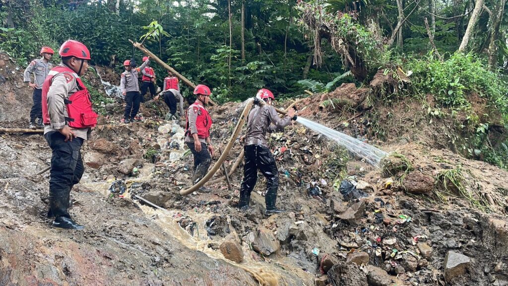 Petugas SAR menyemprot material lumpur di lokasi banjir bandang Bogor