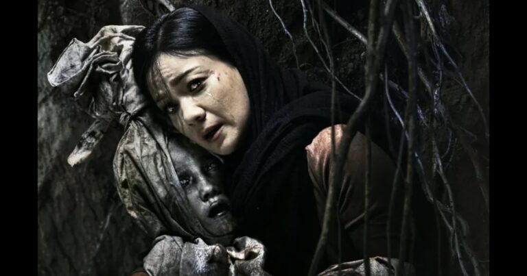 Adegan film Panggilan Dari Kubur—seorang ibu menangis memeluk jasad anaknya di liang gelap berselimut akar.