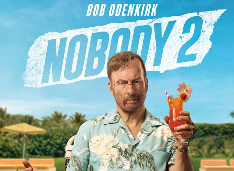 Poster film “Nobody 2” garapan Timo Tjahjanto—seorang pria berkemeja motif tropis memegang minuman, latar langit biru dan judul “NOBODY 2” besar.