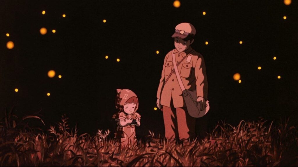 Seita dan Setsuko berdiri di padang rumput malam penuh kunang-kunang dalam film Grave of The Fireflies.