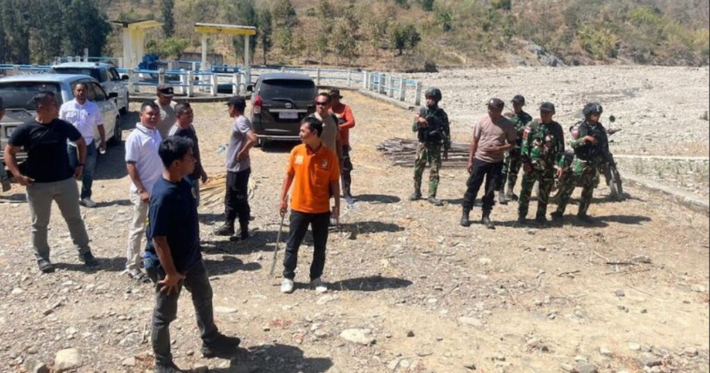 Petugas TNI–Polri dan warga berkumpul di tepi sungai kering dekat perbatasan Timor Leste, meninjau lokasi investigasi setelah WNI tewas tertembak saat berburu.